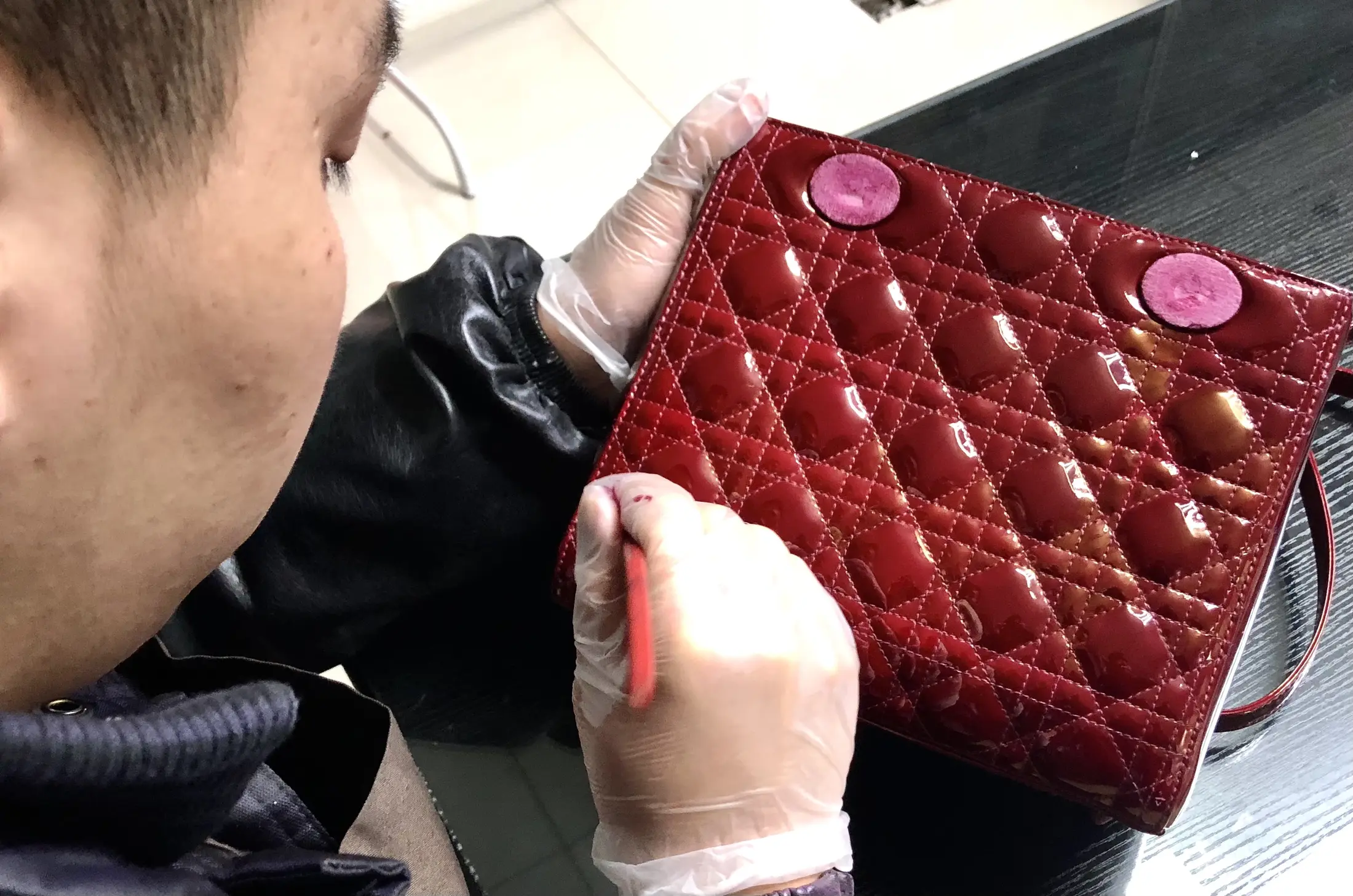 域芭斯护理师正在修复红色漆皮菱格包