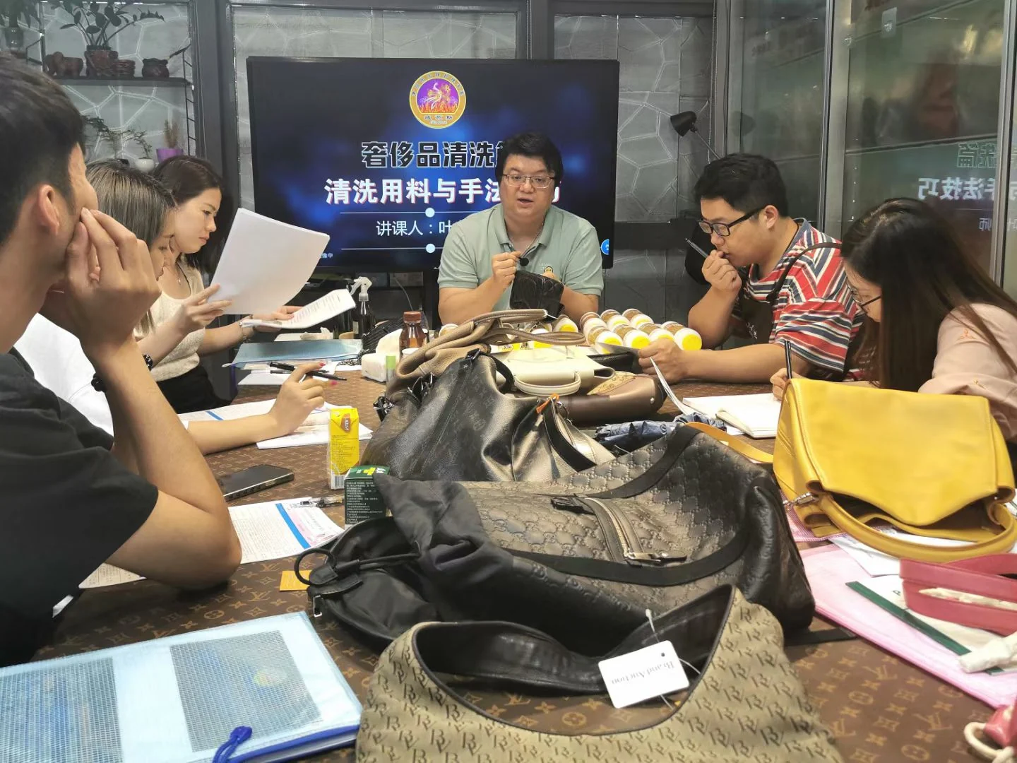 Students observing a demonstration around a table